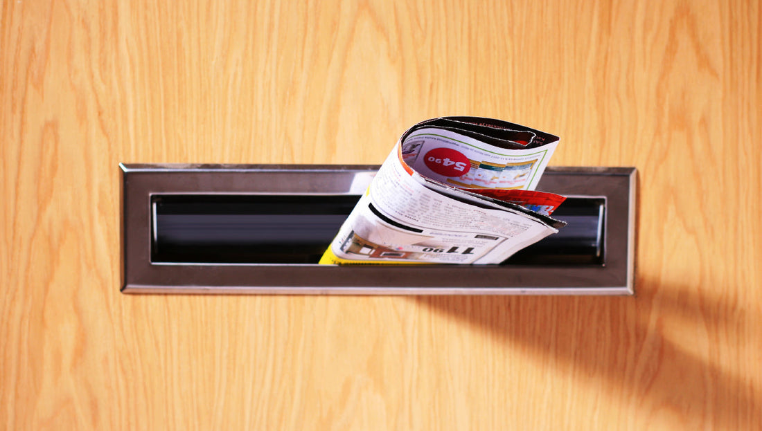A direct mail brochure folded into a mail slot on a door