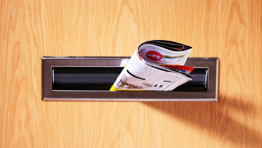 A direct mail brochure folded into a mail slot on a door